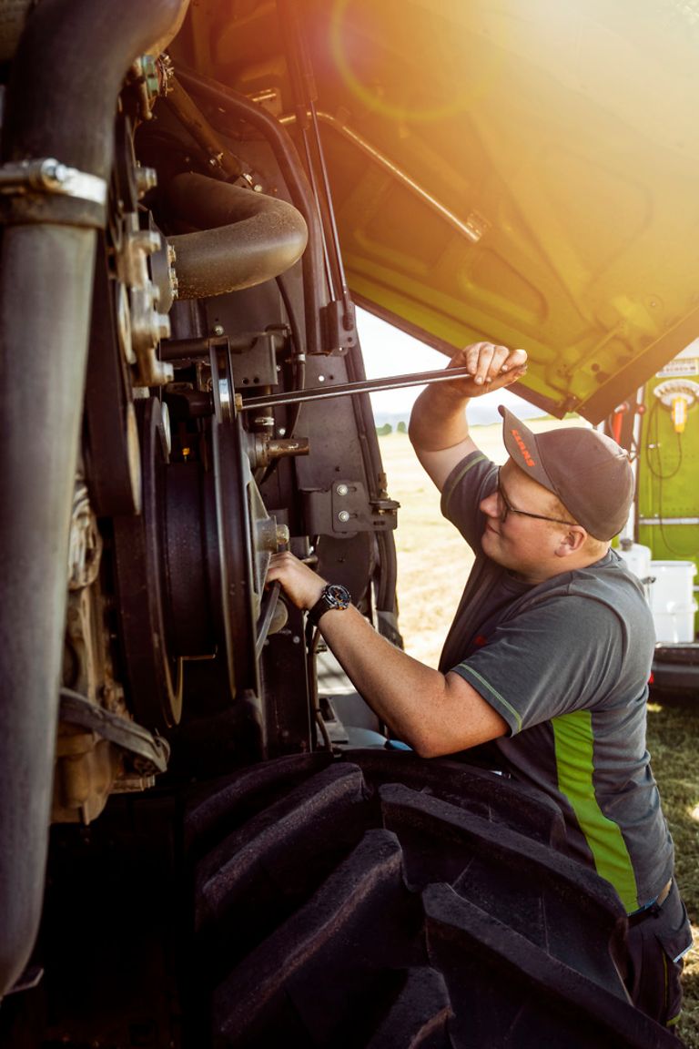 salespartner-stage-pig Un mécatronicien de machines agricoles resserre un boulon sur une ensileuse