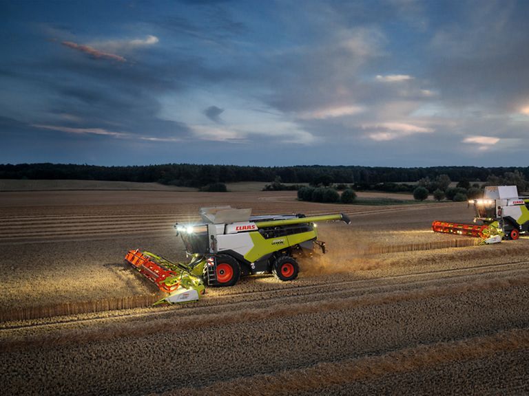 460034_27 LEXION 6900 con CONVIO 1080 nella raccolta del frumento, di sera con le luci di lavoro accese.